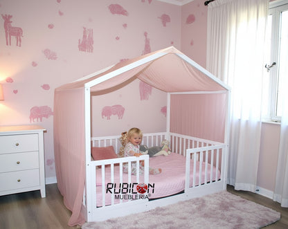 Cama Montessori casita de madera natural con barandales y dosel rosa, ideal para habitación infantil. Rubicon Mueblería.